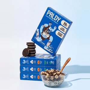 Paldy Cookies & Cream high protein cereal boxes stacked with cookies and a bowl of cereal